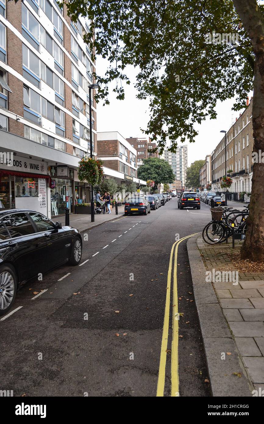 September 19, 2014, London, UK, view of the street with houses of shops and passing cars. Stock Photo