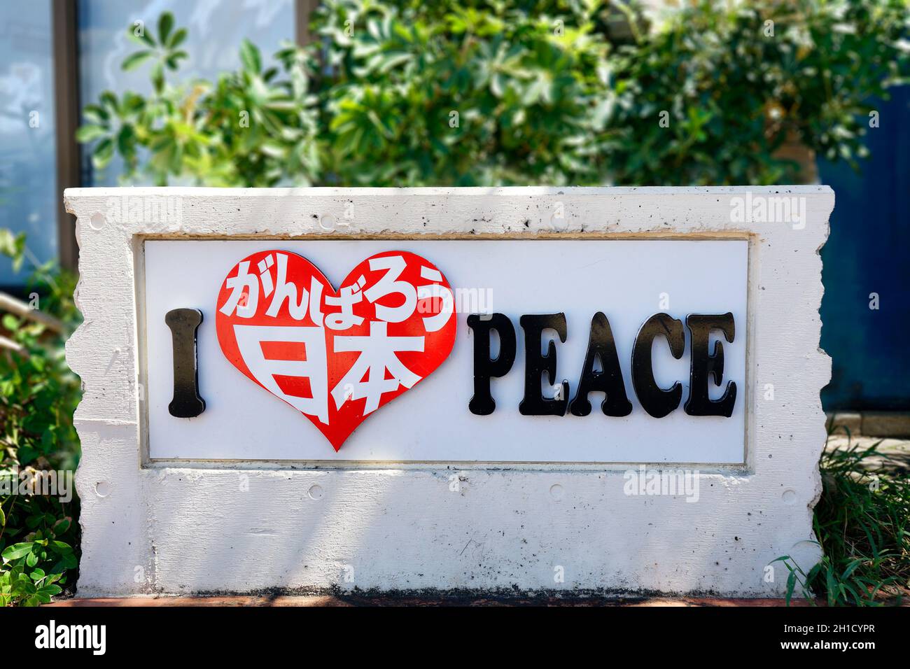 Stone sign where is inscribed in a heart shape I love Peace Let's do our best Japan in the Okinawa market shop mall of the American village in Okinawa Stock Photo