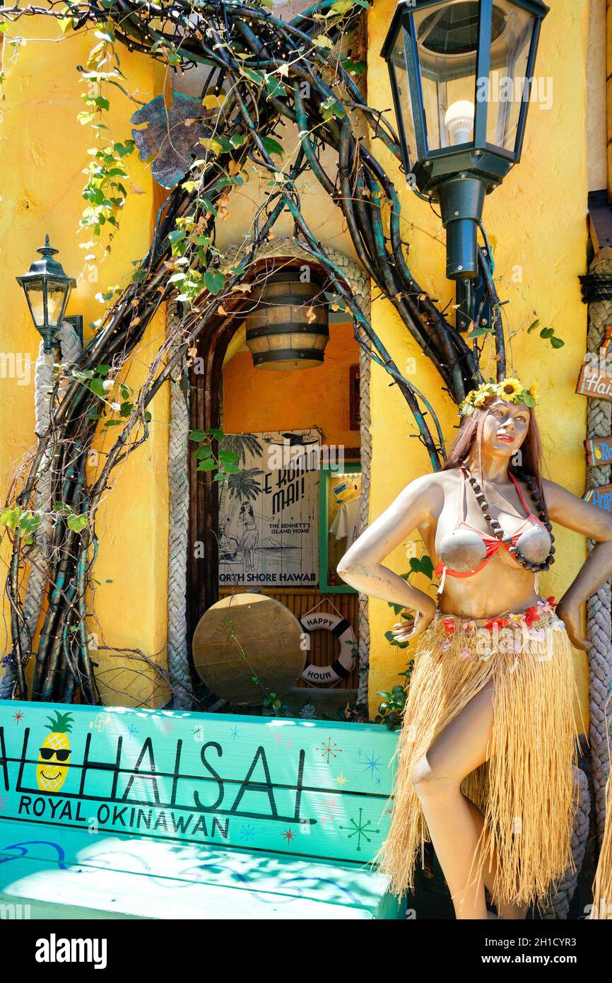 Mannequin doll of a tropical dancer wearing an hawaiian hula dancer grass skirt and a coconut bra in the shop mall of the American village of Chatan C Stock Photo