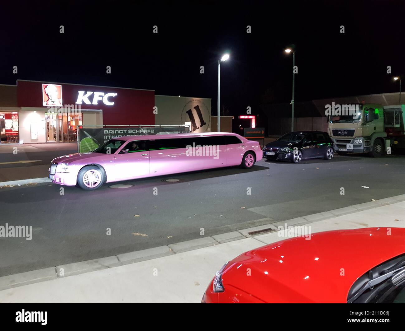 VELBERT, NRW, GERMANY - NOVEMBER 17, 2018: A pink stretch limousine waits for the arrival of passengers in front of a Kentucky Fried Chicken restauran Stock Photo