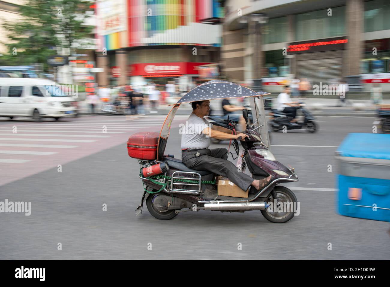 Chongqing, China - August 2019 : Man riding dangerously fast in a scooter on the congested street Stock Photo