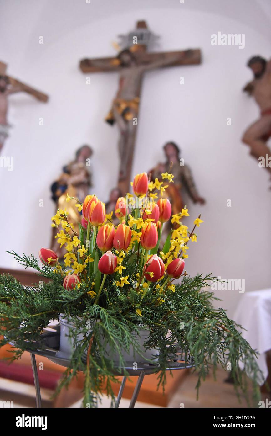 Zu Ostrern werden viele Kirchen mit Frühlingsblumen dekoriert, in diesem Fall mit einem Tulpen-Strauß. - Many churches in Ostrern are decorated with s Stock Photo