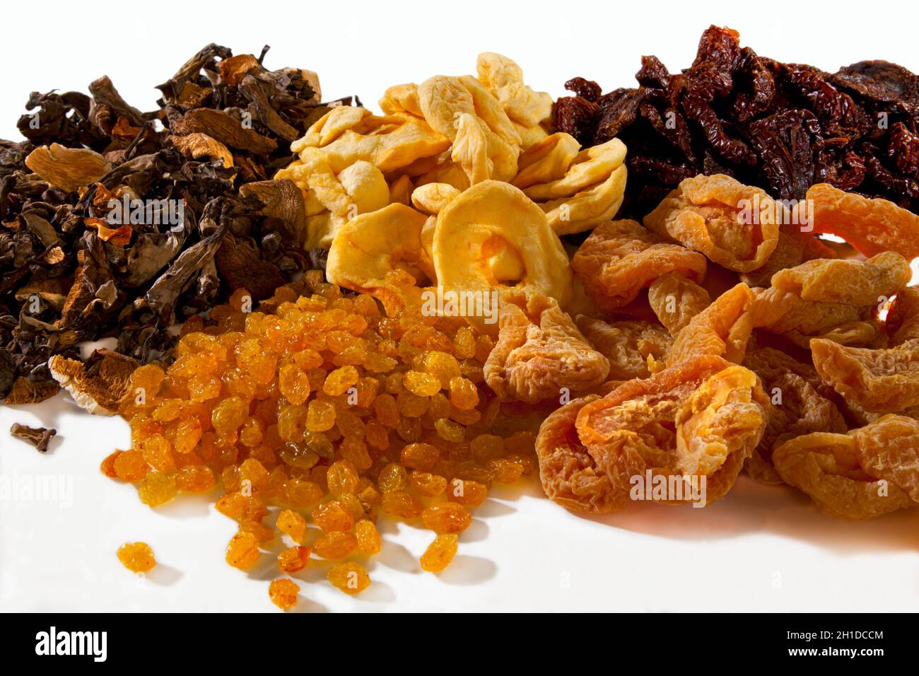 Dried fruits apple rings apricots sultanas dates dried mushrooms on white background copy space porcini Stock Photo