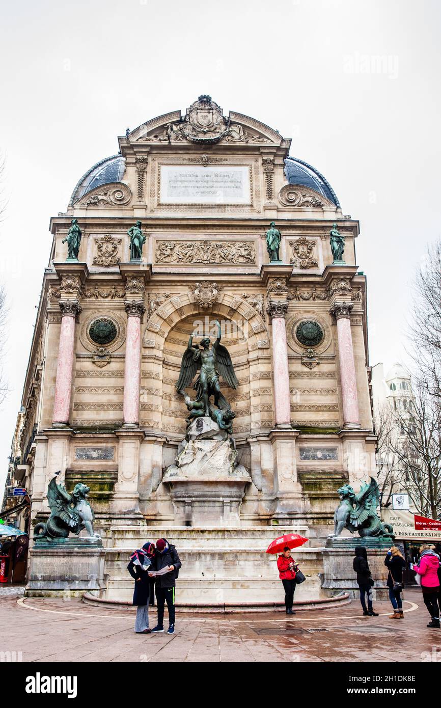 PARIS, FRANCE - MARCH, 2018: Tourists at the Saint Michel Fountain in a freezing winter day Stock Photo