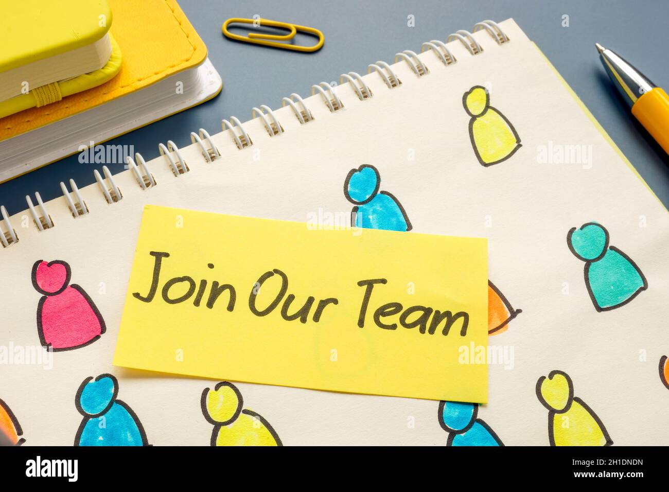 Join our team and notebook with drawn figures. Stock Photo