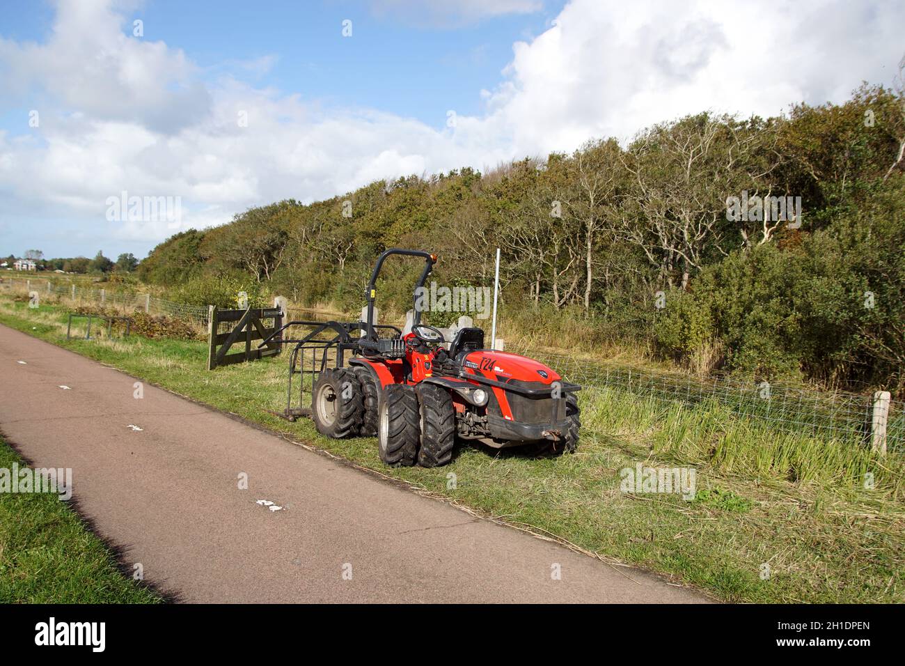 Tractor Antonio carraro TTR 4400. Dual tires for wet nature reserve. Water, reeds, forest, bike path, Near the Dutch village of Bergen in autumn Stock Photo