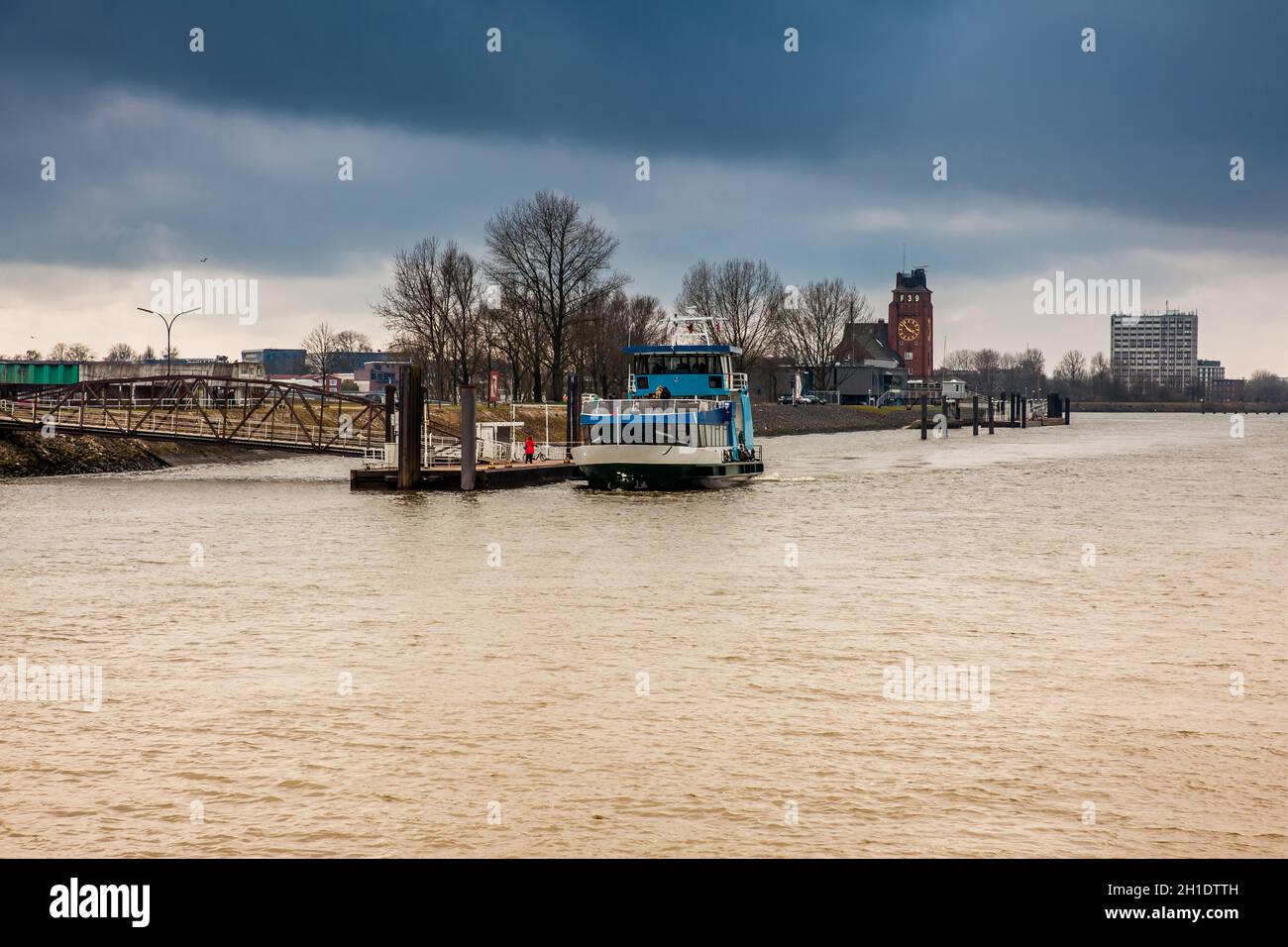 HAMBURG, GERMANY - MARCH, 2018: Ferry navigating on the Elbe river in a cold cloudy winter day in Hamburg Stock Photo
