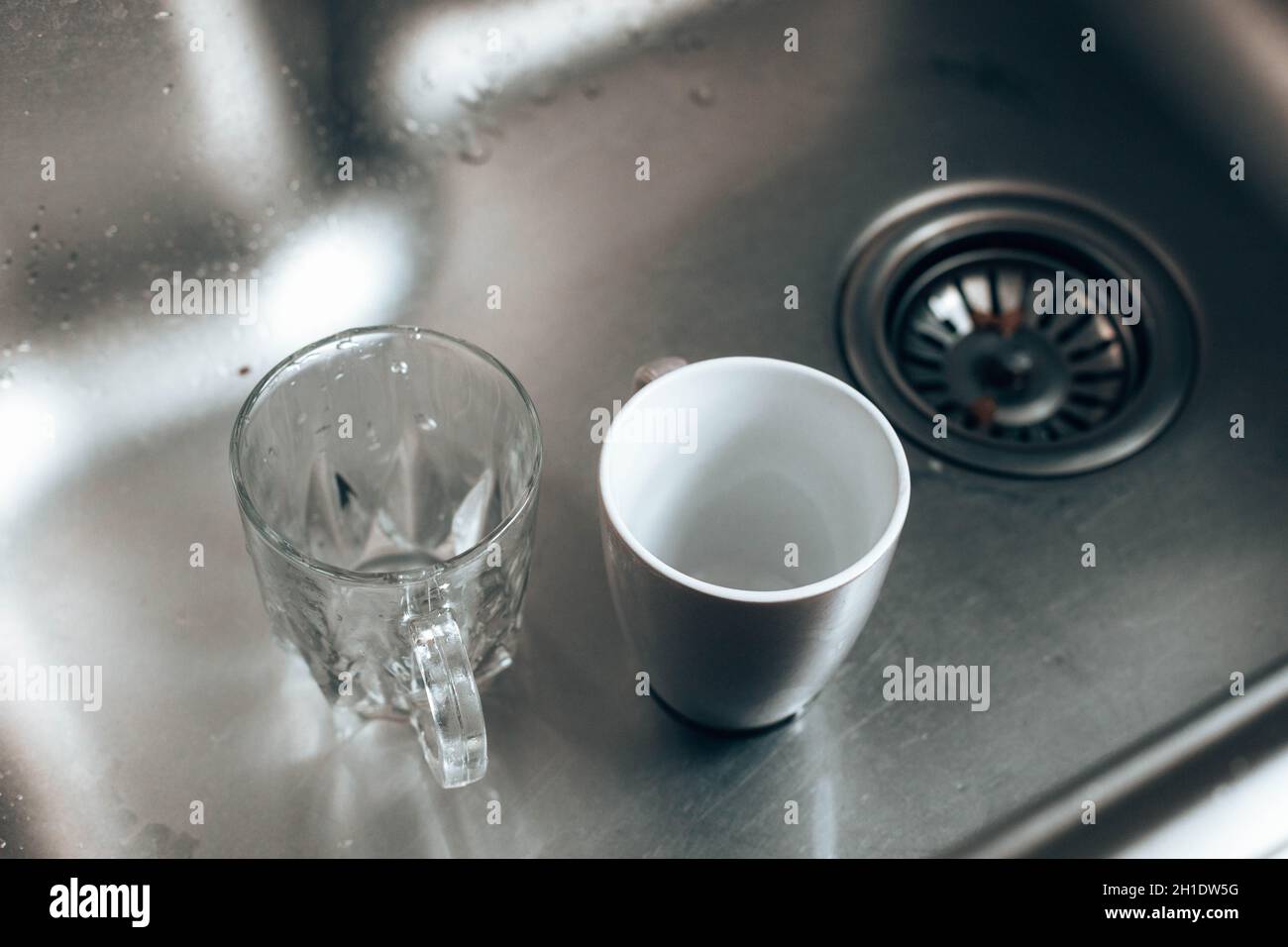 Dirty glass and ceramic cups in the sink, washing up Stock Photo Alamy