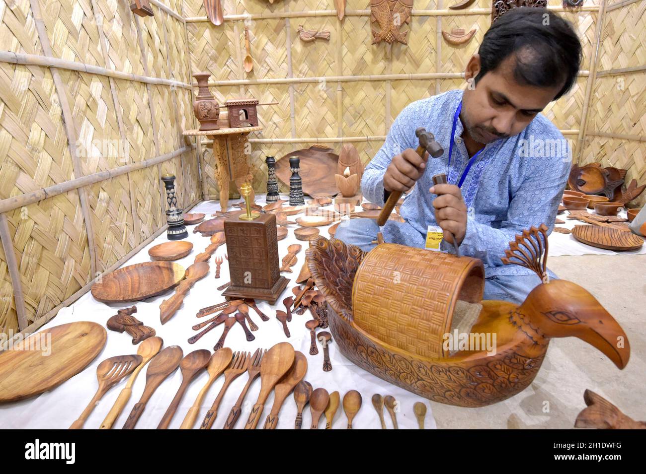 Dhaka. 18th Oct, 2021. An artist makes wooden showpiece during an