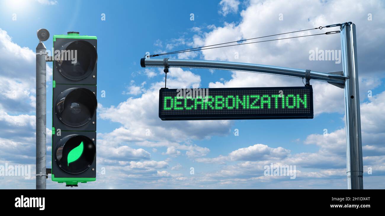 Traffic light with leaf symbol and road information board with text DECARBONIZATION on a background of blue sky. Carbon neutrality concept Stock Photo