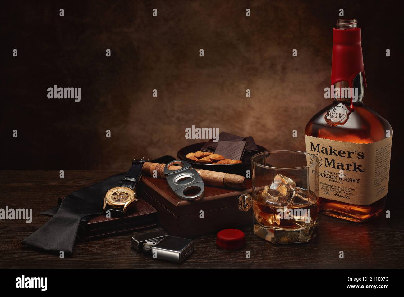 St.Petersburg, Russia - March 2020 - Still life with bottle of Maker's Mark kentucky straight bourbon whisky, glass, box with cigar, nuts and chocolat Stock Photo