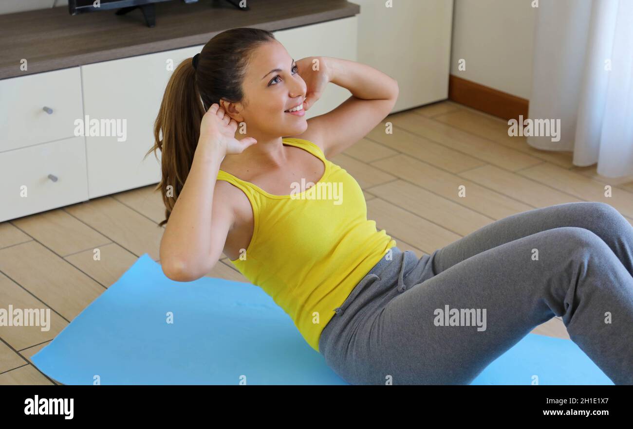 Slim sporty girl doing abs workout. Fitness woman doing strength