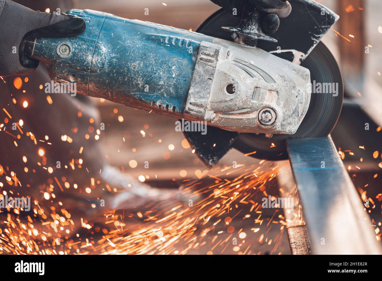 Construction worker using Angle Grinder cutting Metal at construction site . Stock Photo