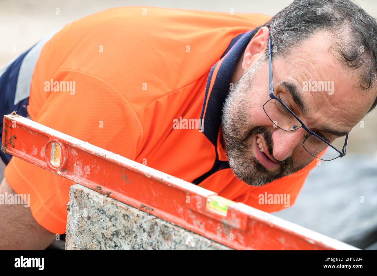Construction worker checking the bubble level while working at construction site. Building construction . Stock Photo