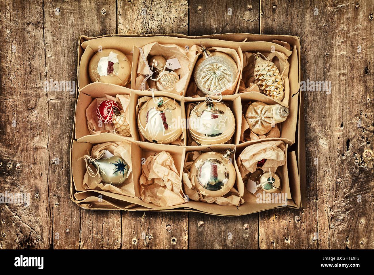 Retro styled image of vintage Christmas decoration in a box on a wooden floor Stock Photo