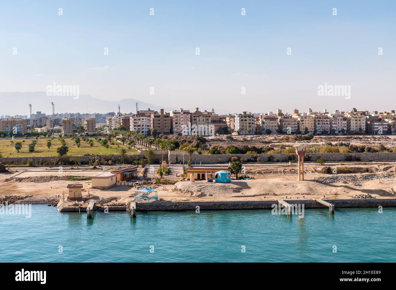 Suez, Egypt - November 5, 2017: Residential buildings on the shore of Suez Canal in Egypt, Africa. Military watch tower in the foreground. Stock Photo