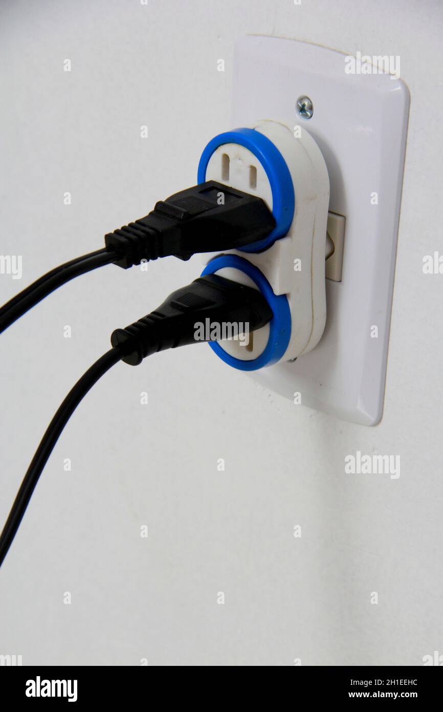 salvador, bahia / brazil - november 10, 2013: household electrical outlet is seen with several plugged power cables, situation of risk of short circui Stock Photo