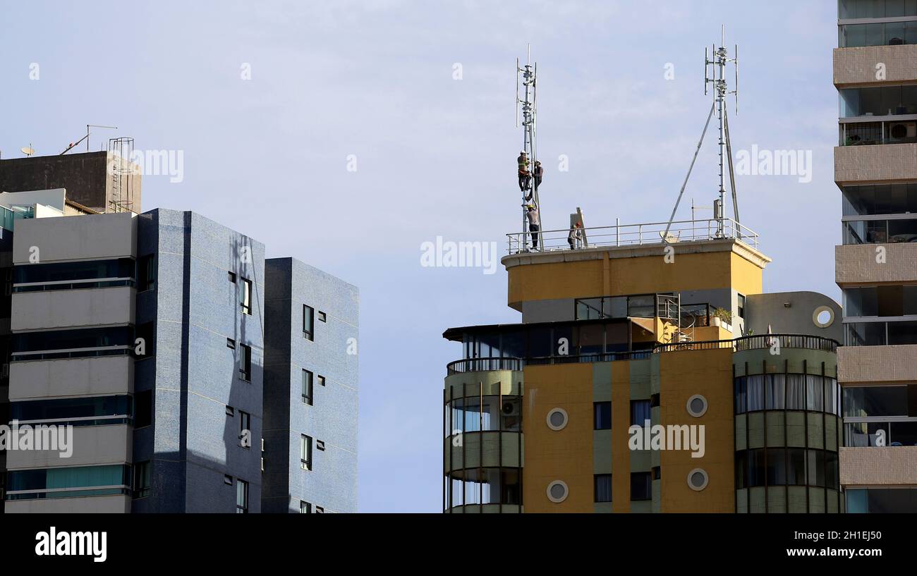 salvador, bahia / brazil - march 15, 2018: Workers are seen working on  mobile phone antennas on a building terrace in the Armacao neighborhood in  the Stock Photo - Alamy