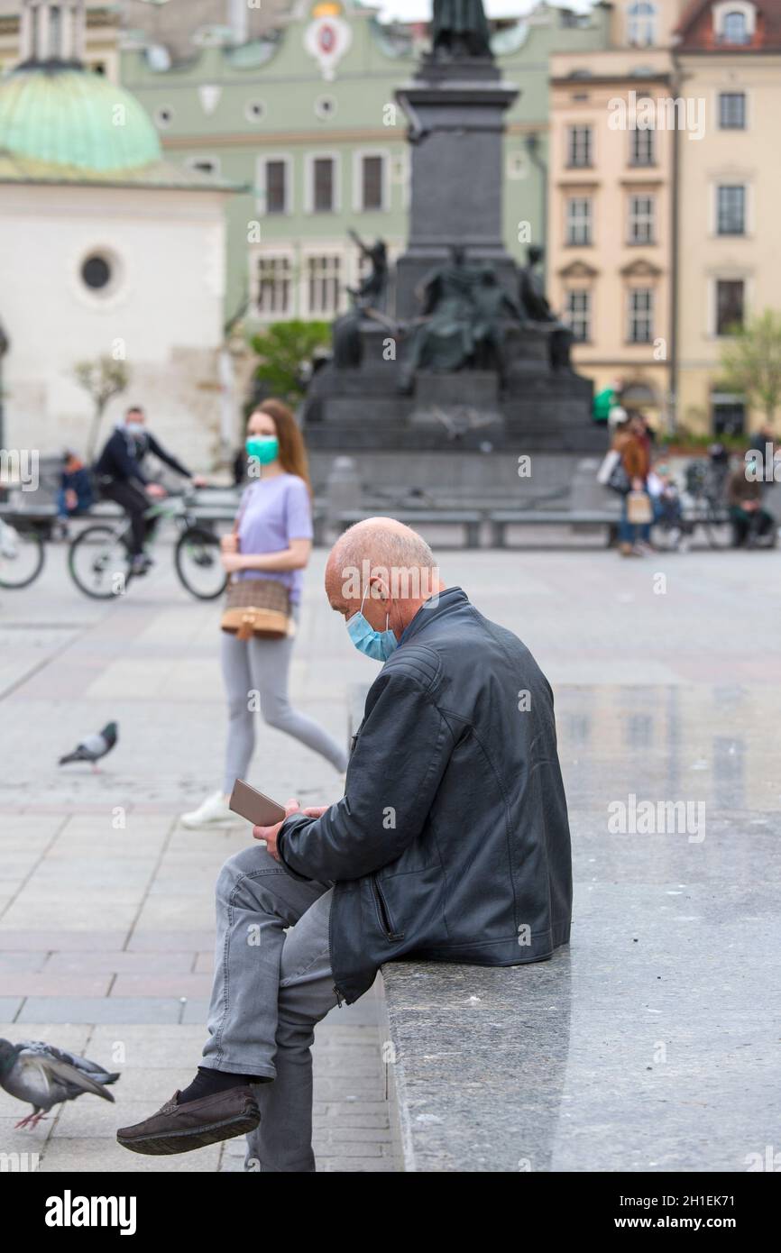 Krakow; Poland - May 2, 2020: Man with a face protective mask. Main Market Square during a coronavirus pandemic, no tourists. Closed state borders Stock Photo