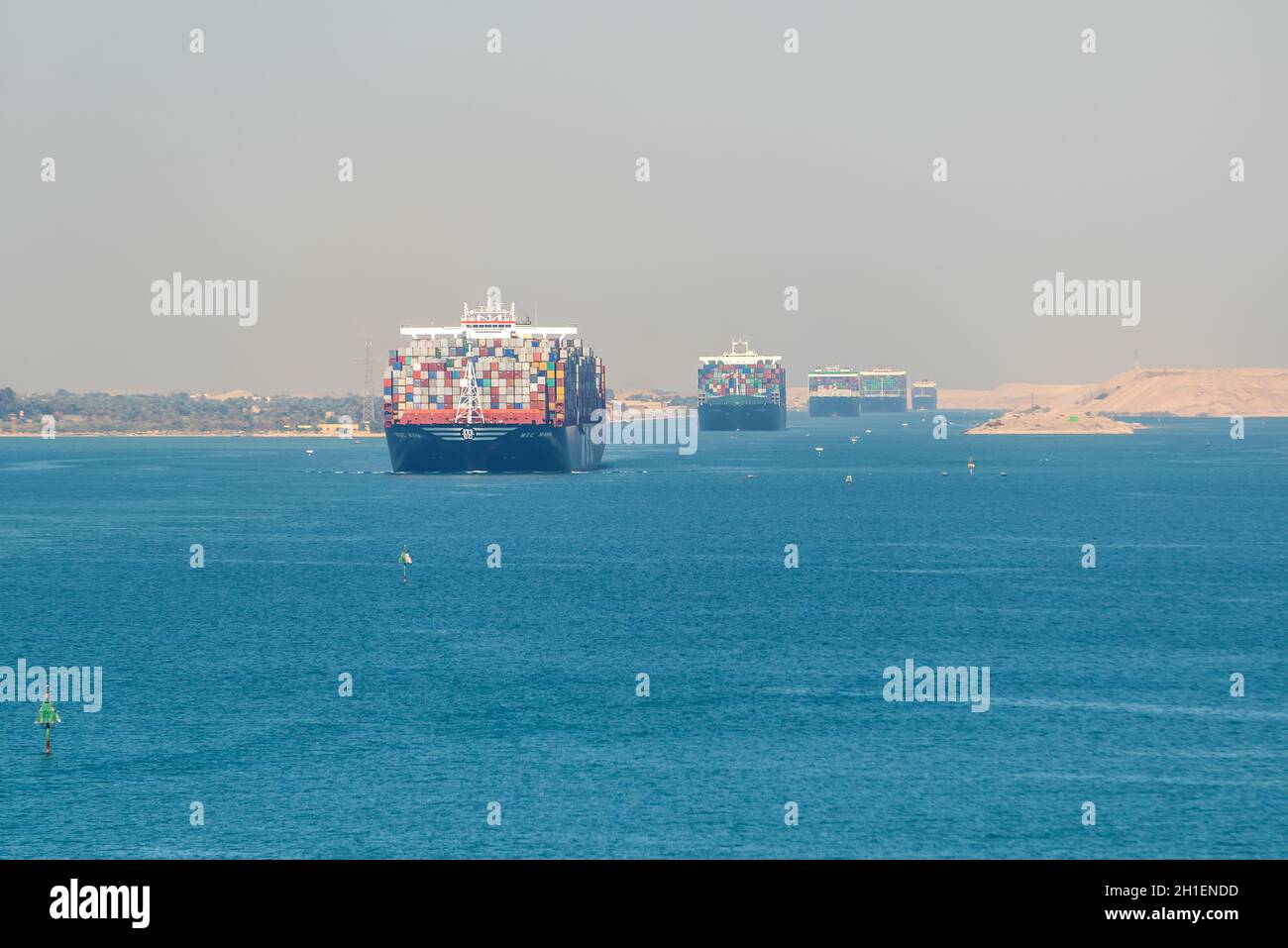 Suez, Egypt - November 5, 2017: Large container vessels (ship) passing Suez Canal in the sandy haze in Egypt. Stock Photo
