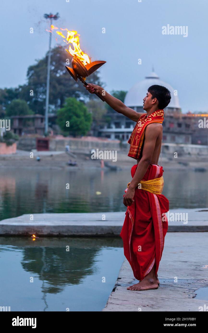 UJJAIN, INDIA - APRIL 23, 2011: Brahmin performing Aarti pooja ceremony on bank of holy river Kshipra. Aarti is Hindu religious ritual of worship, par Stock Photo