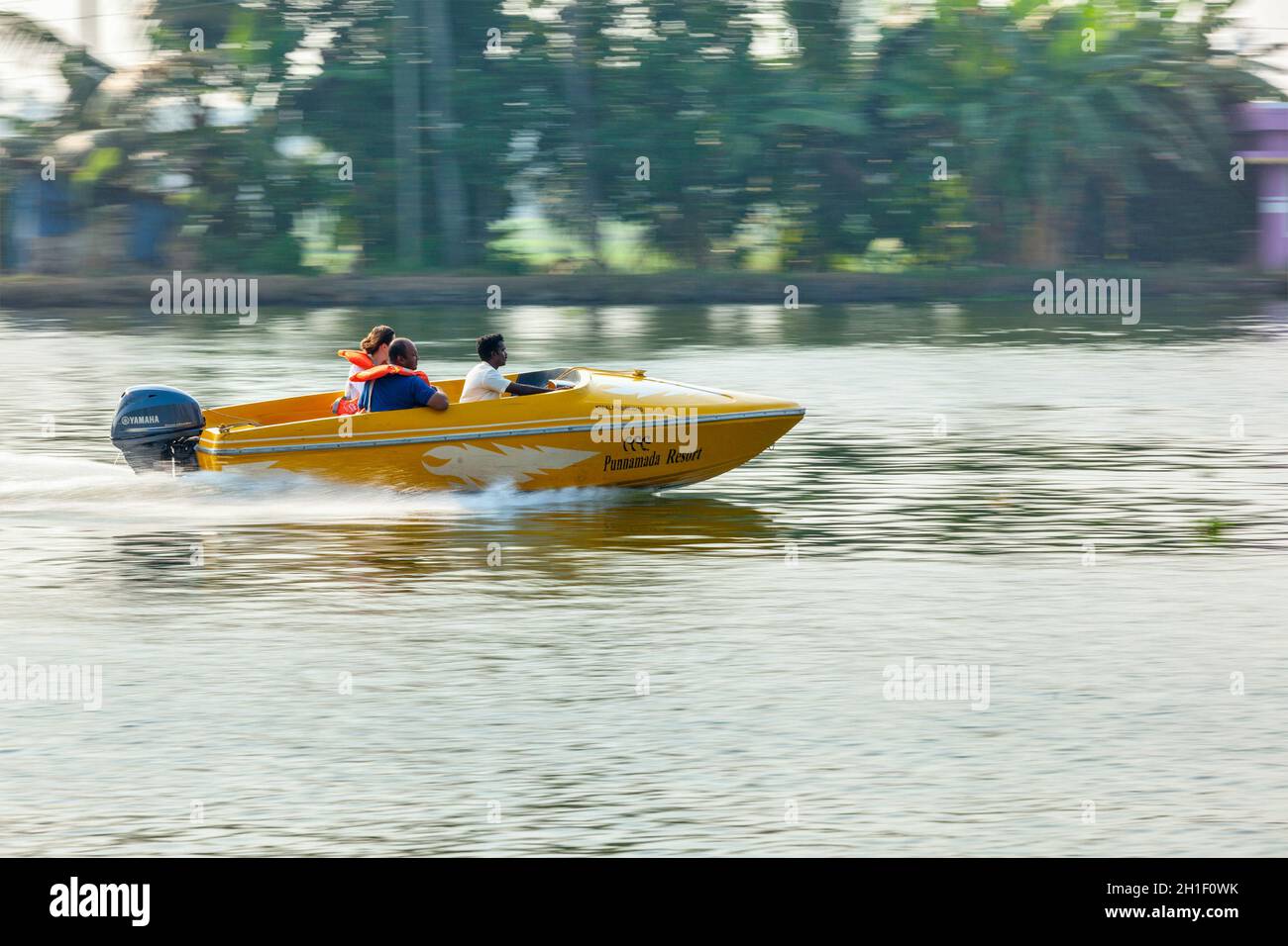 KERALA, INDIA - MAY 5, 2010: Unidentified foreing tourists in speed boat in backwaters. Kerala backwaters are both major tourist attraction and integr Stock Photo