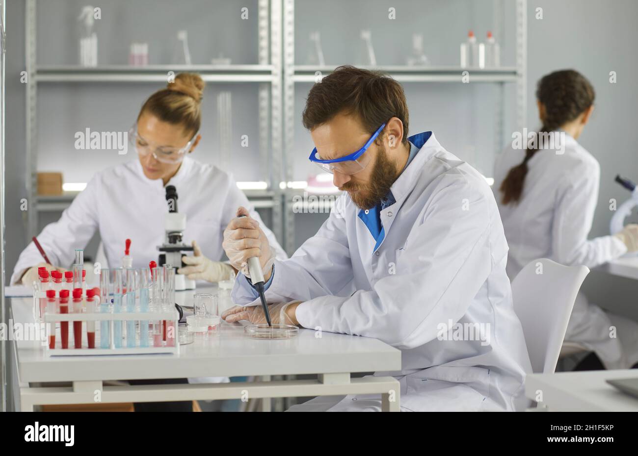 Portrait of three scientists doing research studying substances in modern laboratory Stock Photo