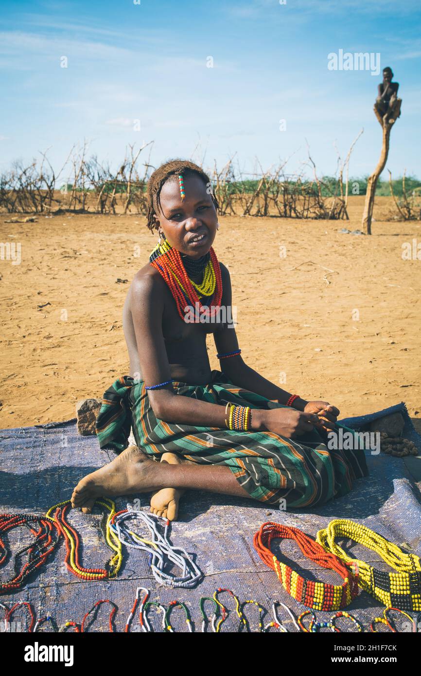 Omorate, Omo Valley, Ethiopia - May 11, 2019: Woman from the African tribe Dasanesh offering handmade souvenirs. Daasanach are Cushitic ethnic group i Stock Photo