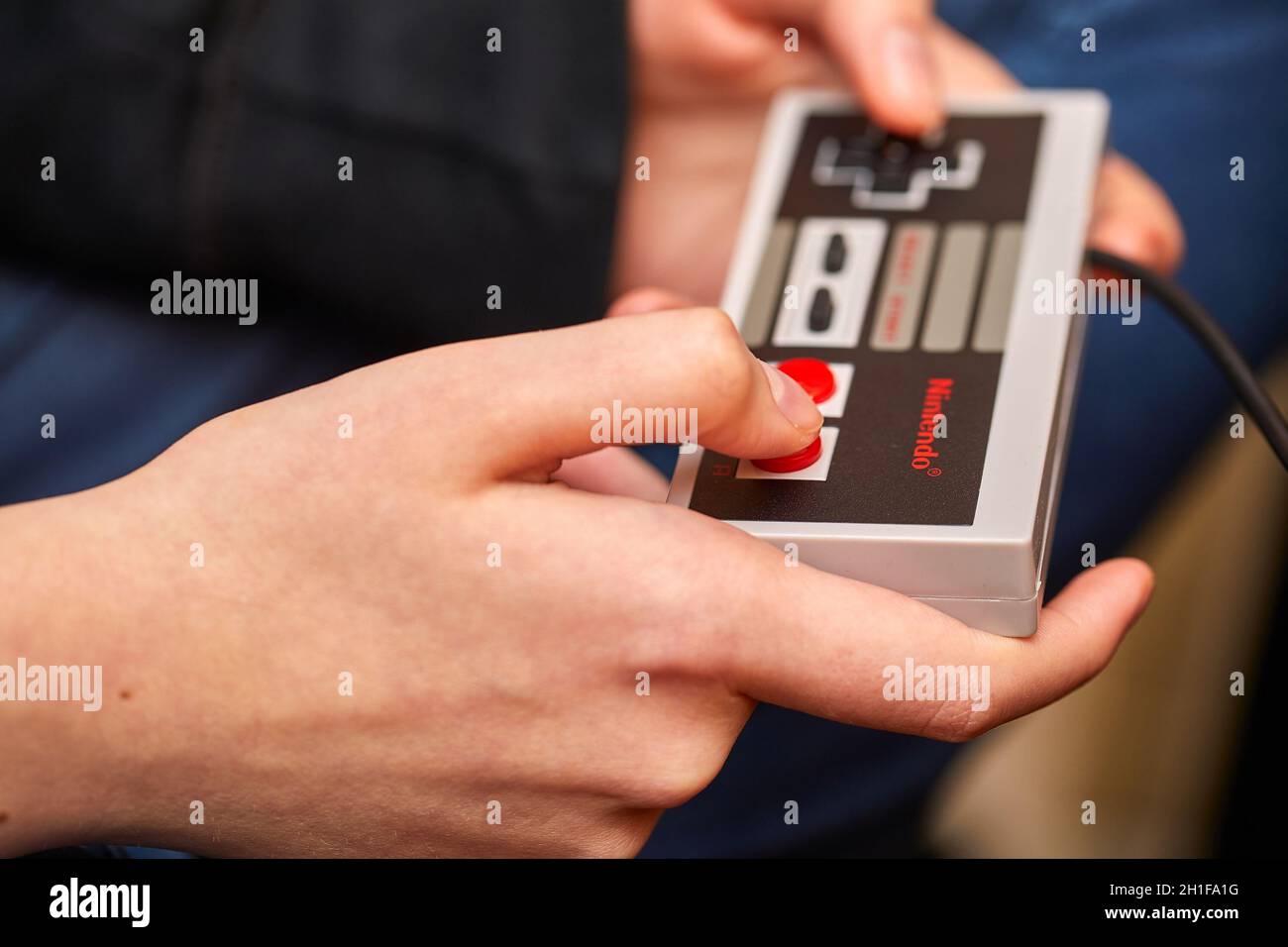 BUDAPEST, HUNGARY - FEBRUARY 17, 2018: Playing the classic Nintendo NES console from the 80s, controller closeup Stock Photo