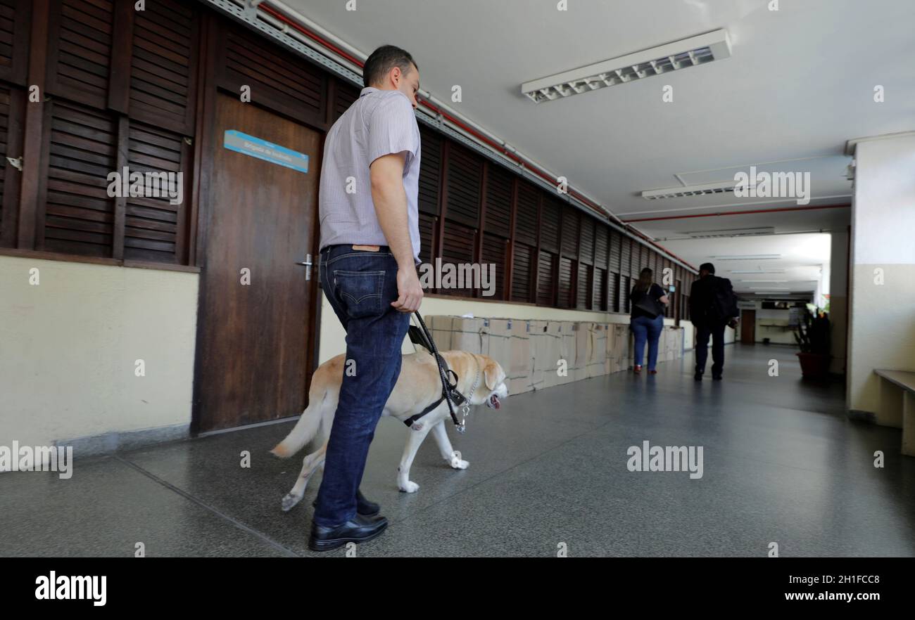 salvador, bahia / brazil - march 20, 2019: visually impaired uses his guide dog to get around the neighborhood of Nazare in salvador city.    *** Loca Stock Photo