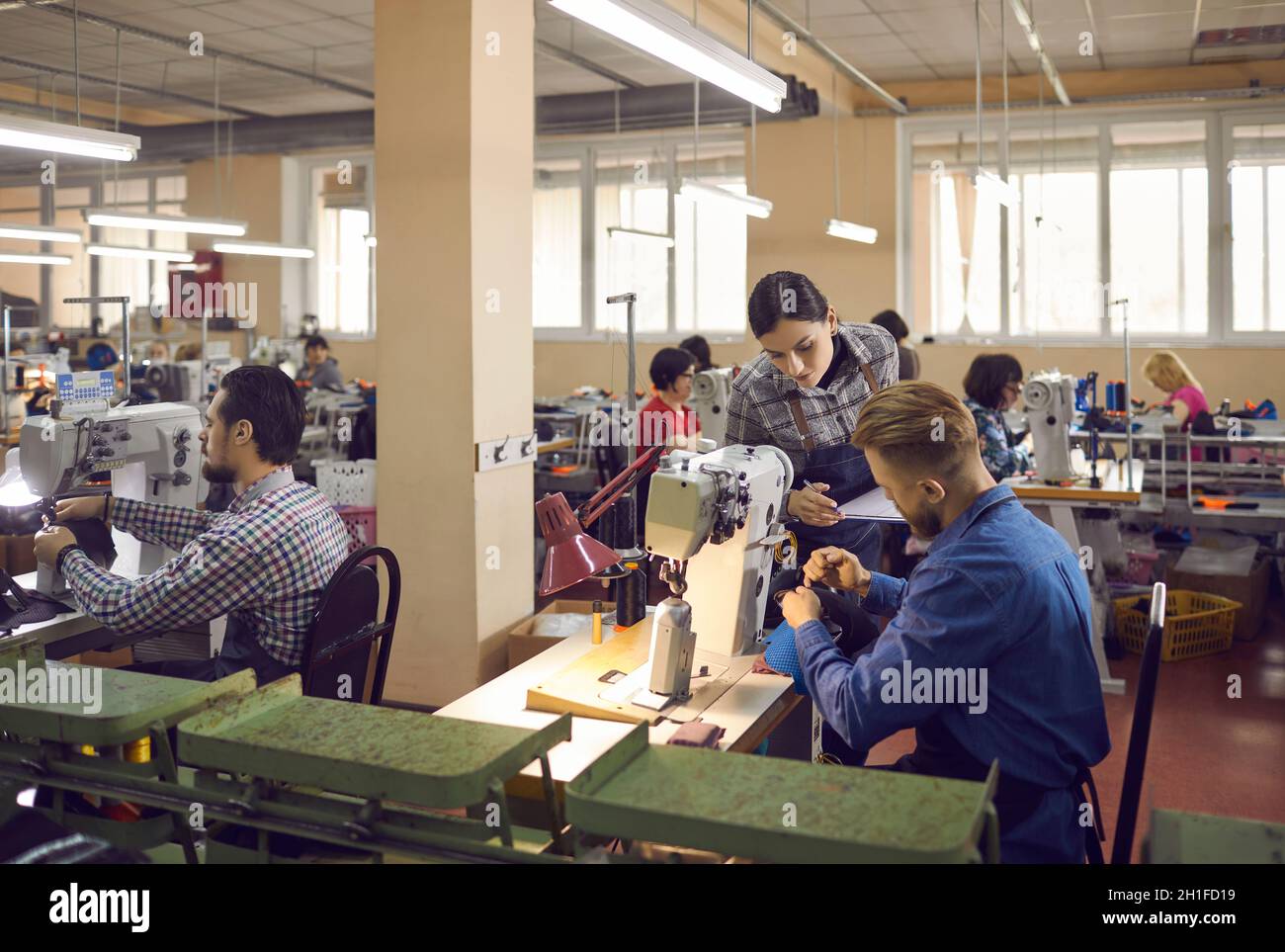 Workers at a shoe factory making new footwear details on industrial