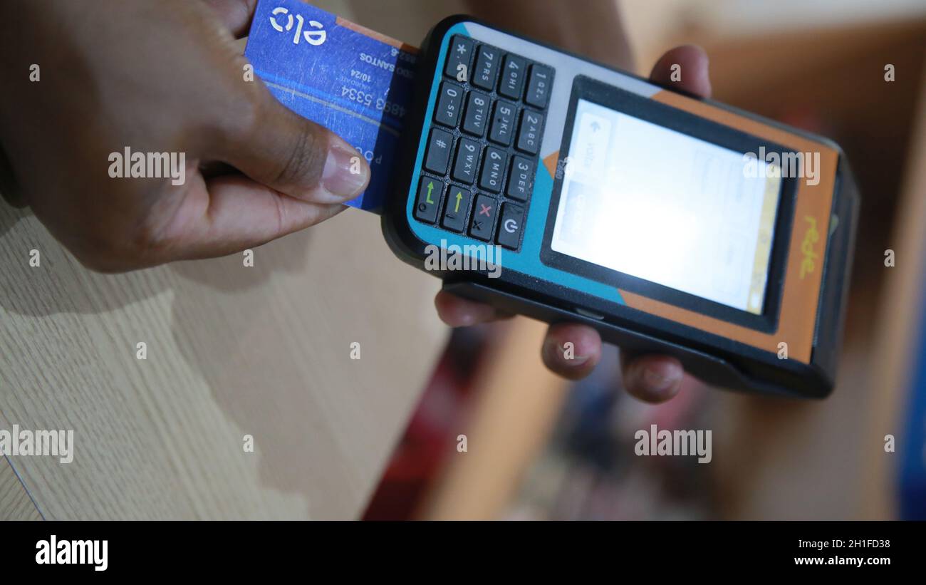 salvador, bahia / brazil - november 22, 2019: person uses credit card machine in shoppng shop in the city of Salvador. *** Local Caption *** Stock Photo