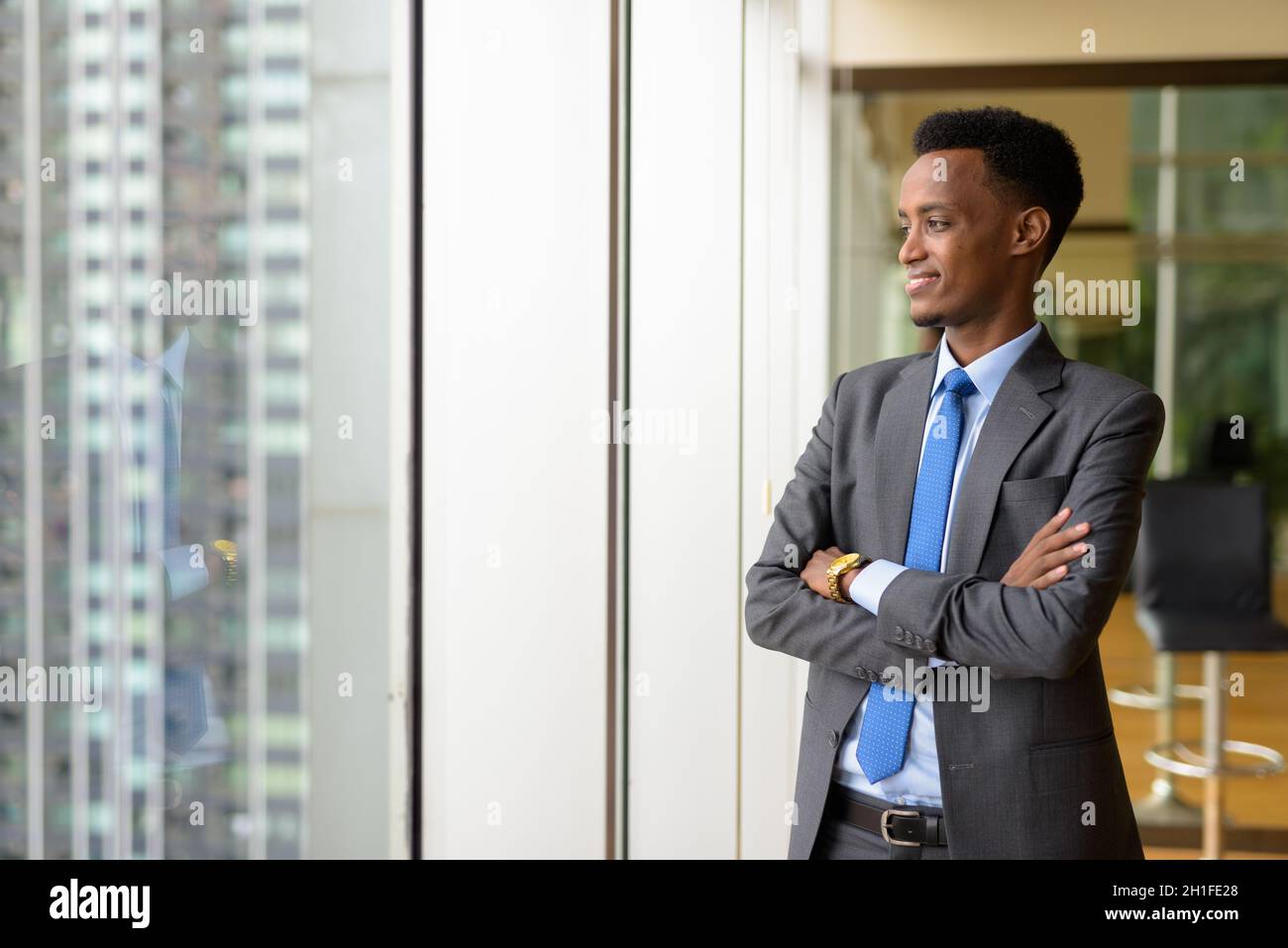 Portrait of handsome young African businessman wearing suit and tie ...