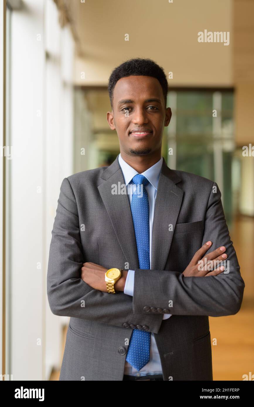 Portrait of handsome young African businessman wearing suit and tie ...