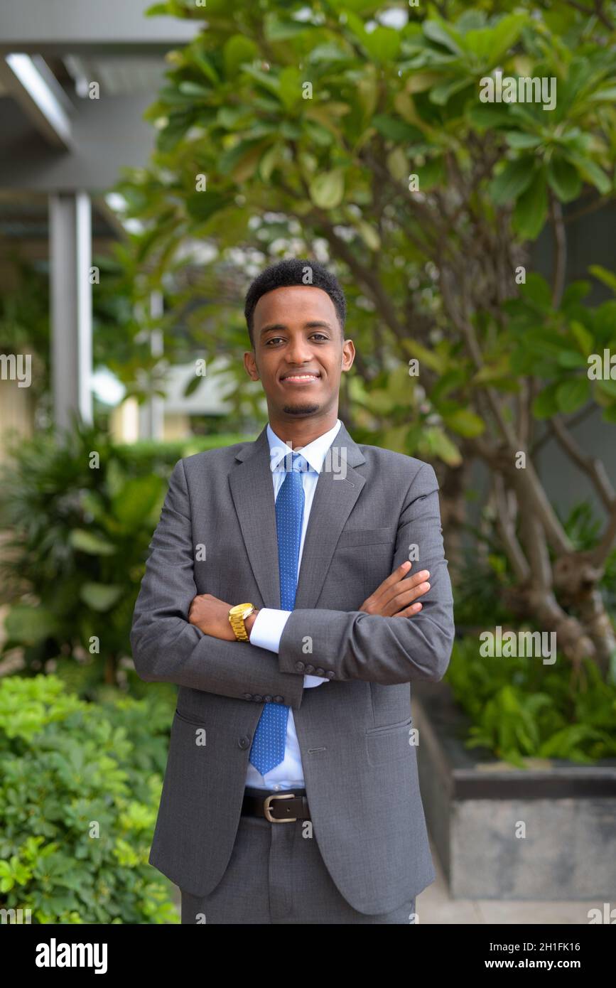 Portrait of handsome young African businessman wearing suit and tie ...
