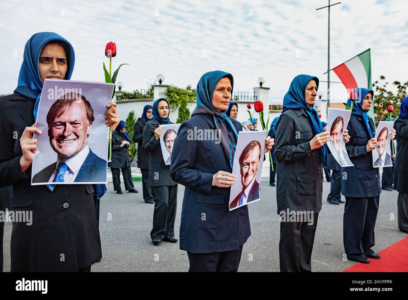 Members of the main Iranian opposition group, the Mojahedin-e Khalq (MEK)  in Ashraf-3, Albania hold pictures of the Sir David Amess, during the  ceremonies in tribute to the late British MP, who