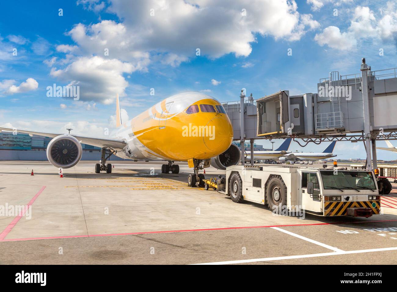 Aircraft tow tractor and airplane in Singapore Changi Airport Stock