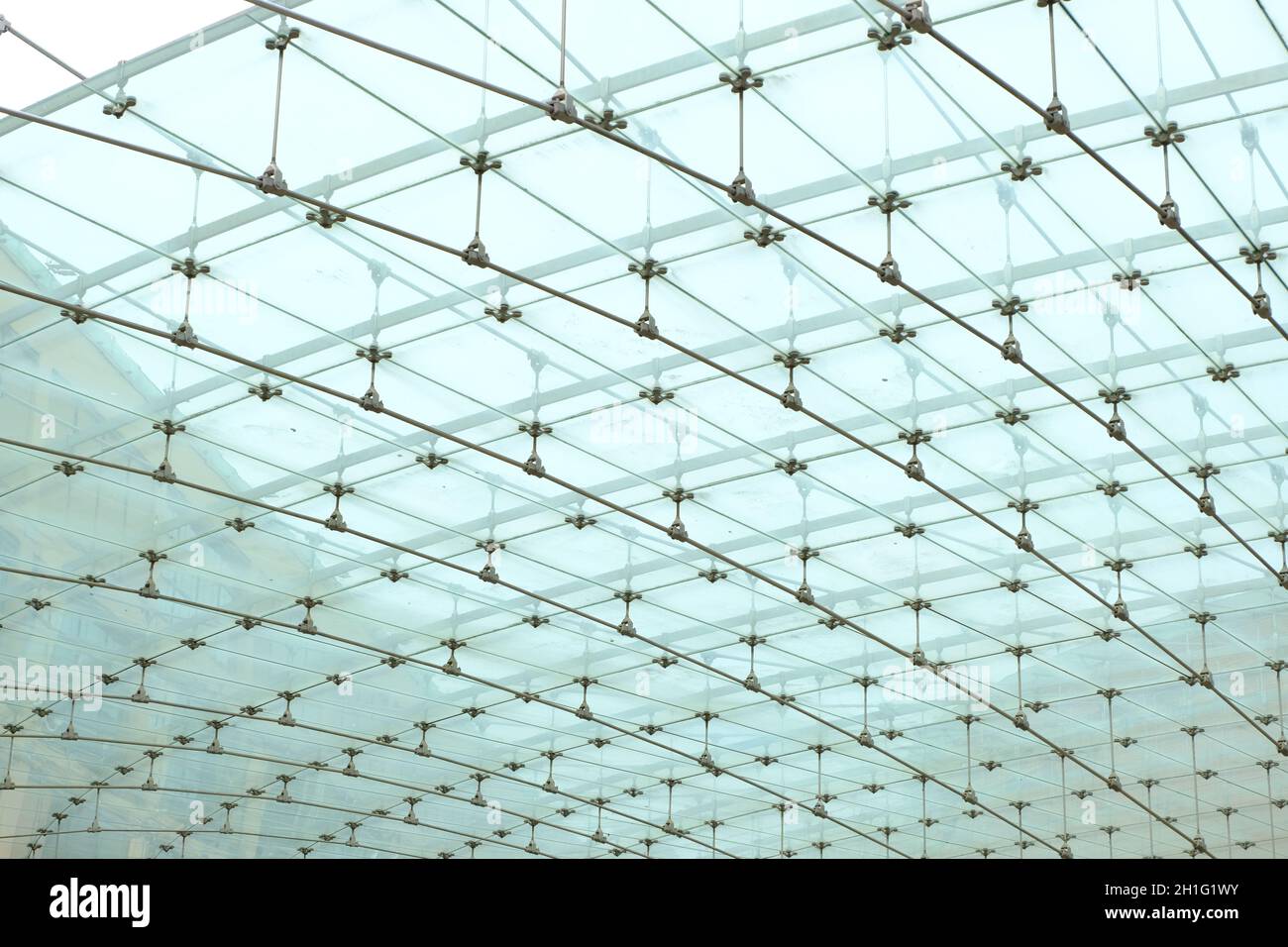 Glass roof of modern square. Glass plates supported by stainless steel cables and struts.   Lodi, Lombardy, Italy. Stock Photo