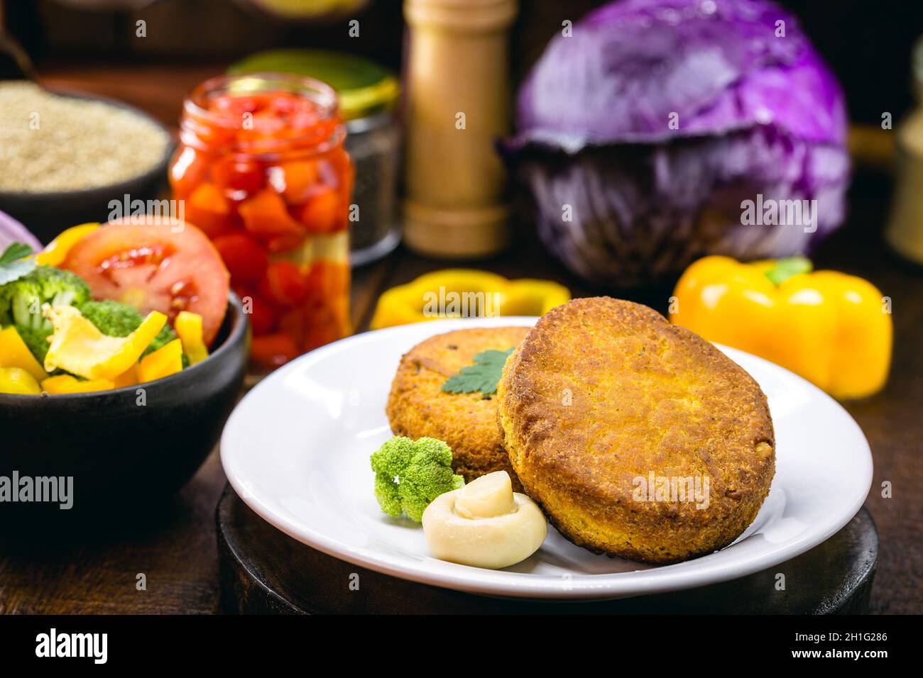 Healthy vegetarian meat free burgers on round chopping board with vegetables  and spinach on light background Stock Photo - Alamy