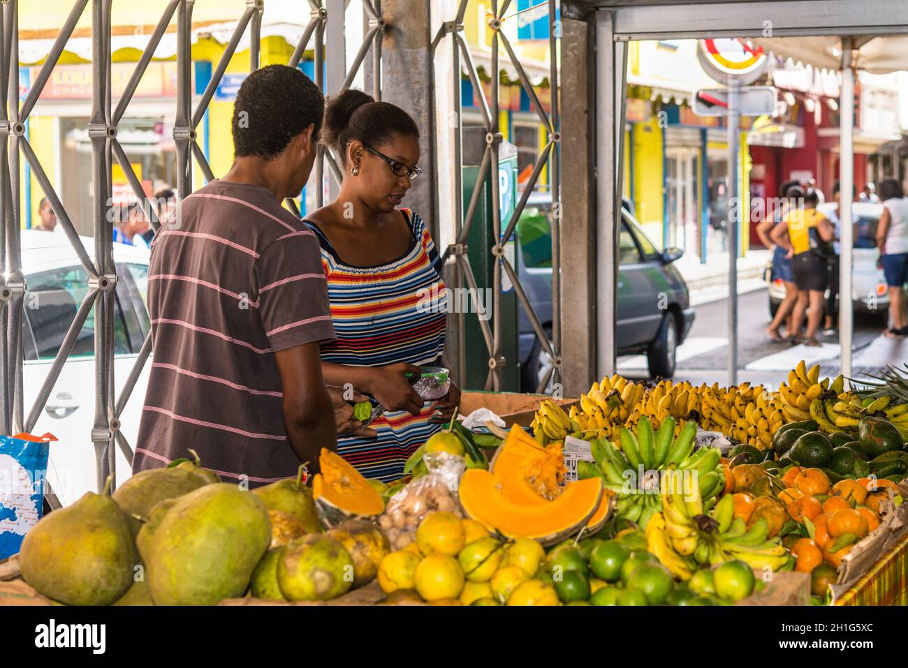Fort-de-France, Martinique - December 19, 2016: A couple of locals pick fruit on the picturesque fruit and vegetable covered market of Fort de France, Stock Photo