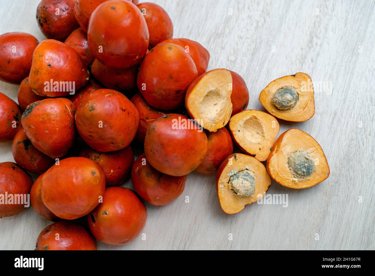 Top view of whole and halved chontaduro fruits on the wooden table Stock Photo