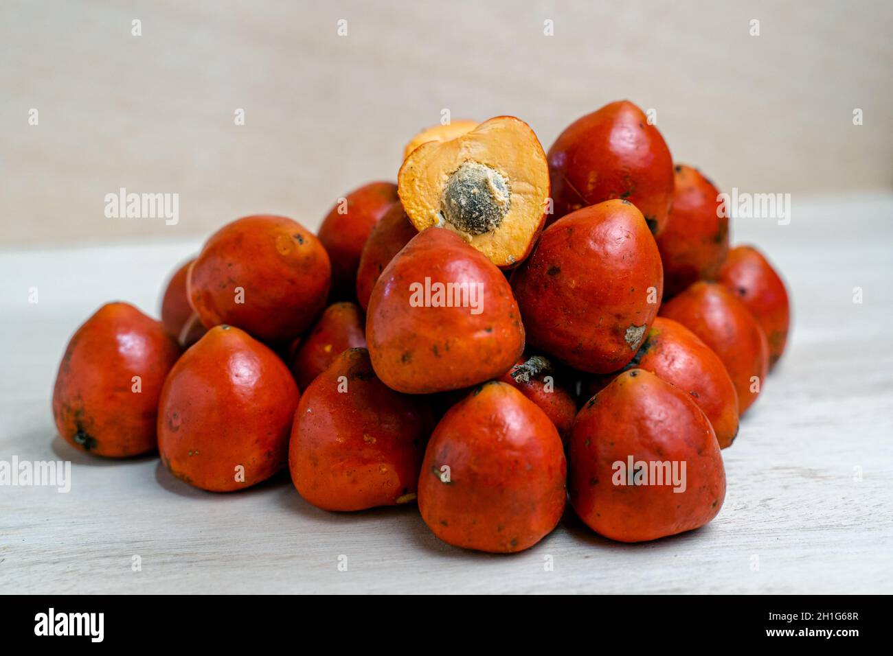 Heap of arranged peach palm fruits on the table Stock Photo