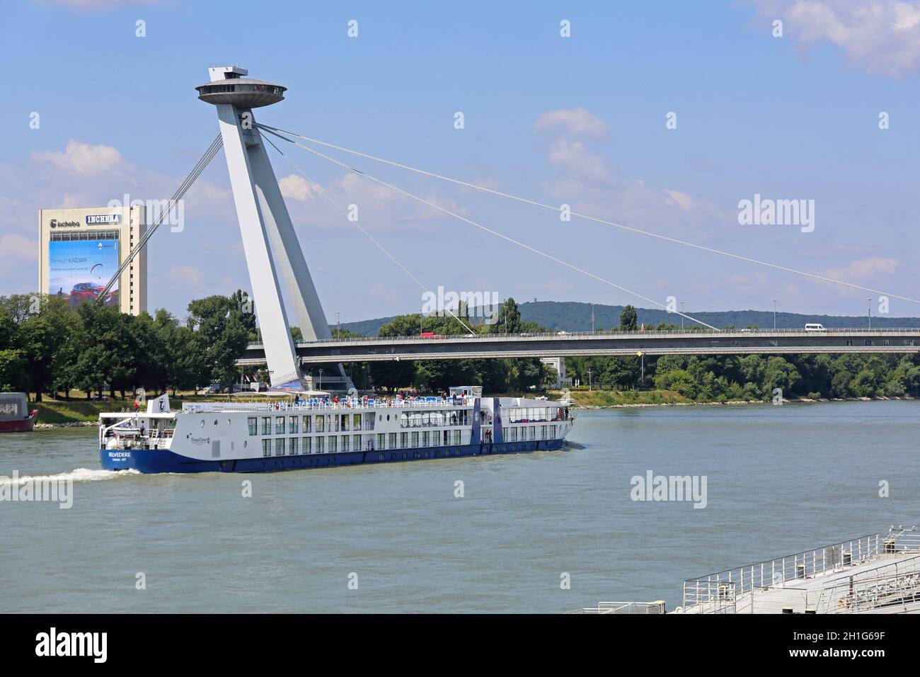 Bratislava, Slovakia - July 10, 2015: Cruiser Ship at River Danube Pass Under Famous UFO Bridge in Bratislava, Slovakia. Stock Photo