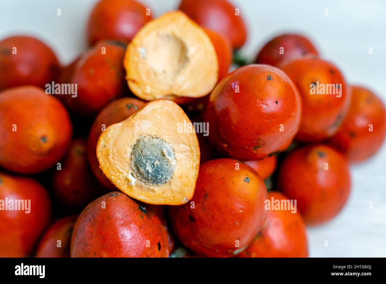 Halved chontaduro on a heap of whole fruits Stock Photo