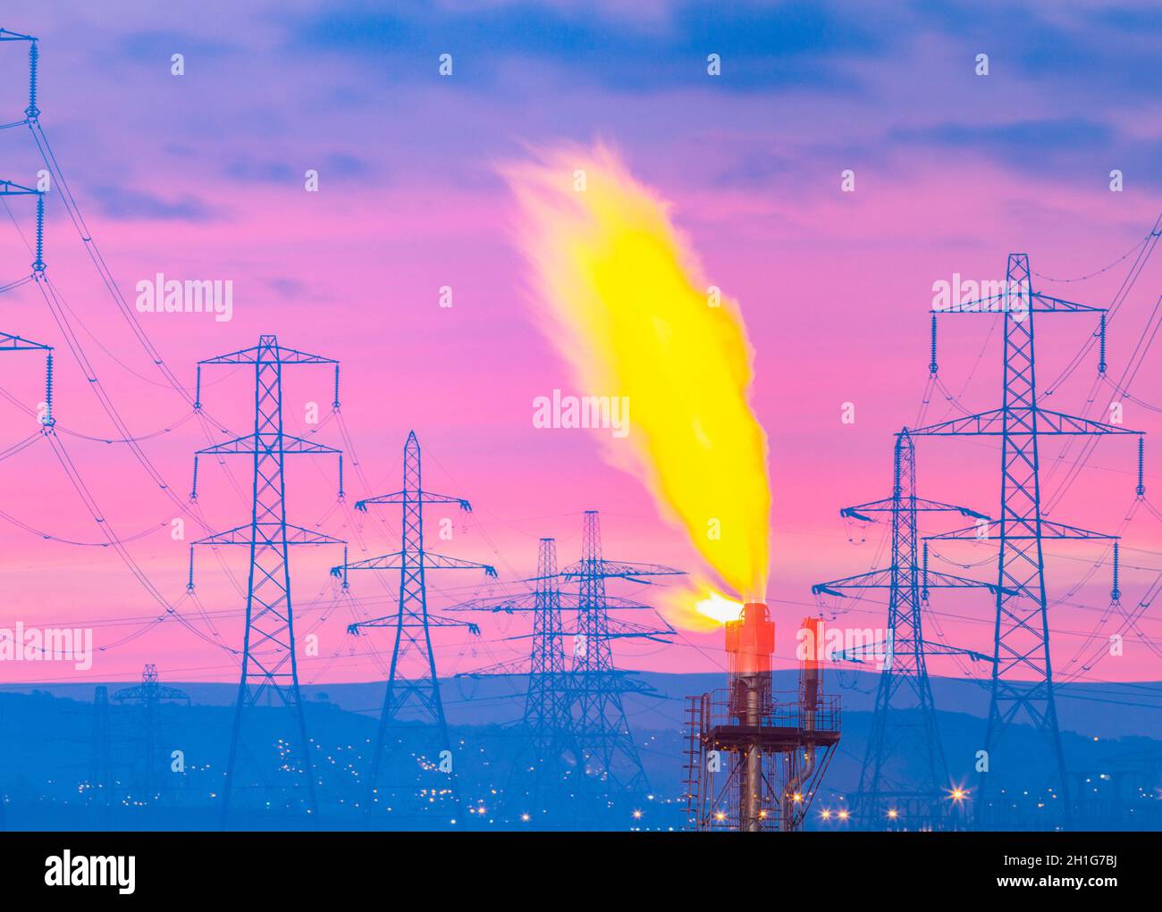 Electricity pylons at sunrise with industrial/chemical plant gas flare