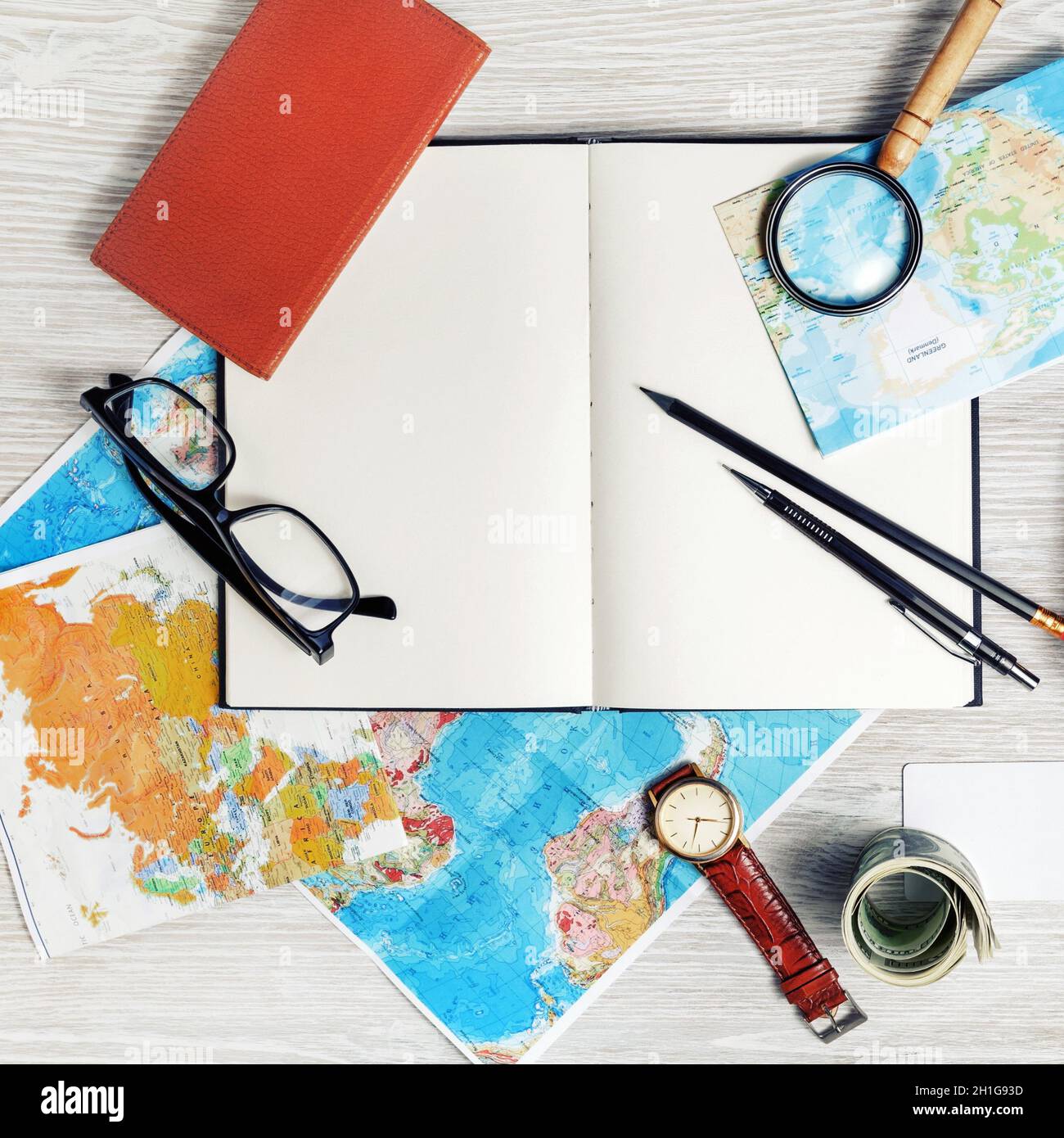 Making travel plan. Map, blank book, magnifier, glasses, notebook, pencils, clock and money. Top view. Flat lay. Stock Photo