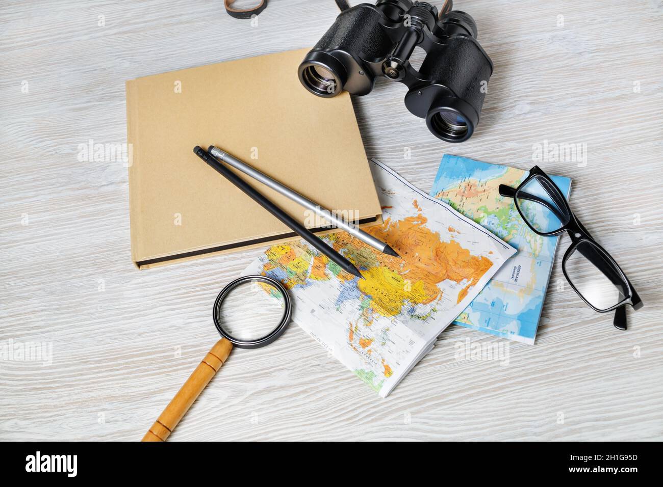 Travel plan background. Ready for the trip. Map, book, magnifier, binocular, pencils and glasses. Stock Photo