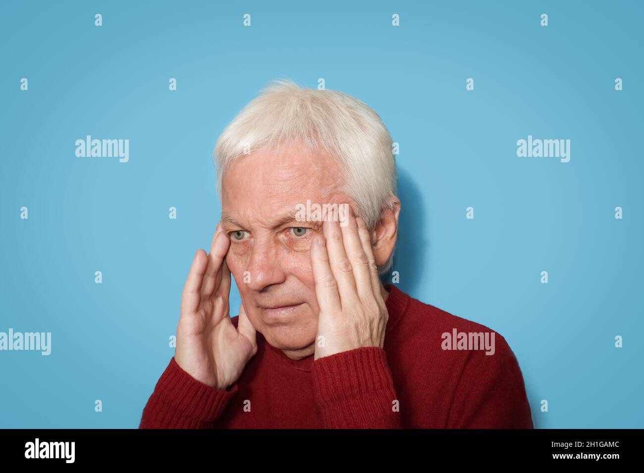 White haired man having headache isolated over blue background Stock Photo
