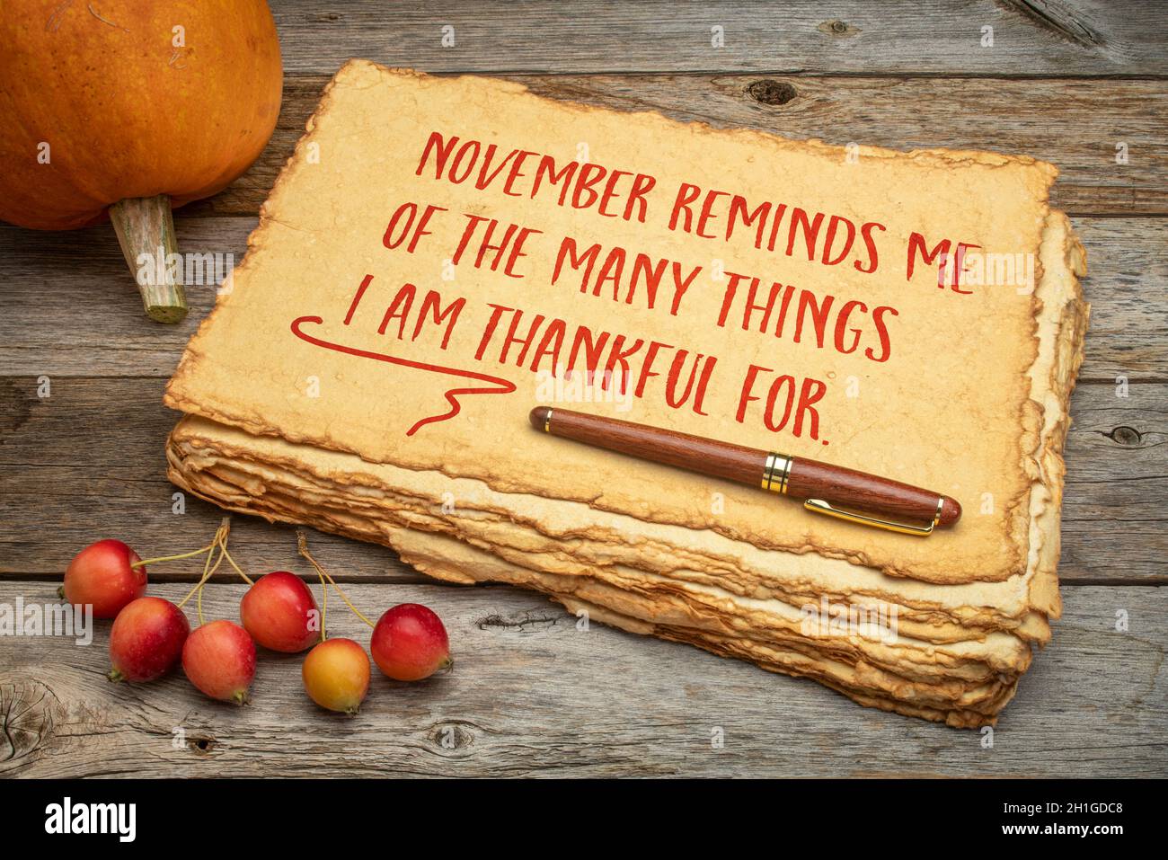 November reminds me of the many things I am grateful for - inspirational words for Thanksgiving, handwriting on a handmade paper with a pumpkin and cr Stock Photo