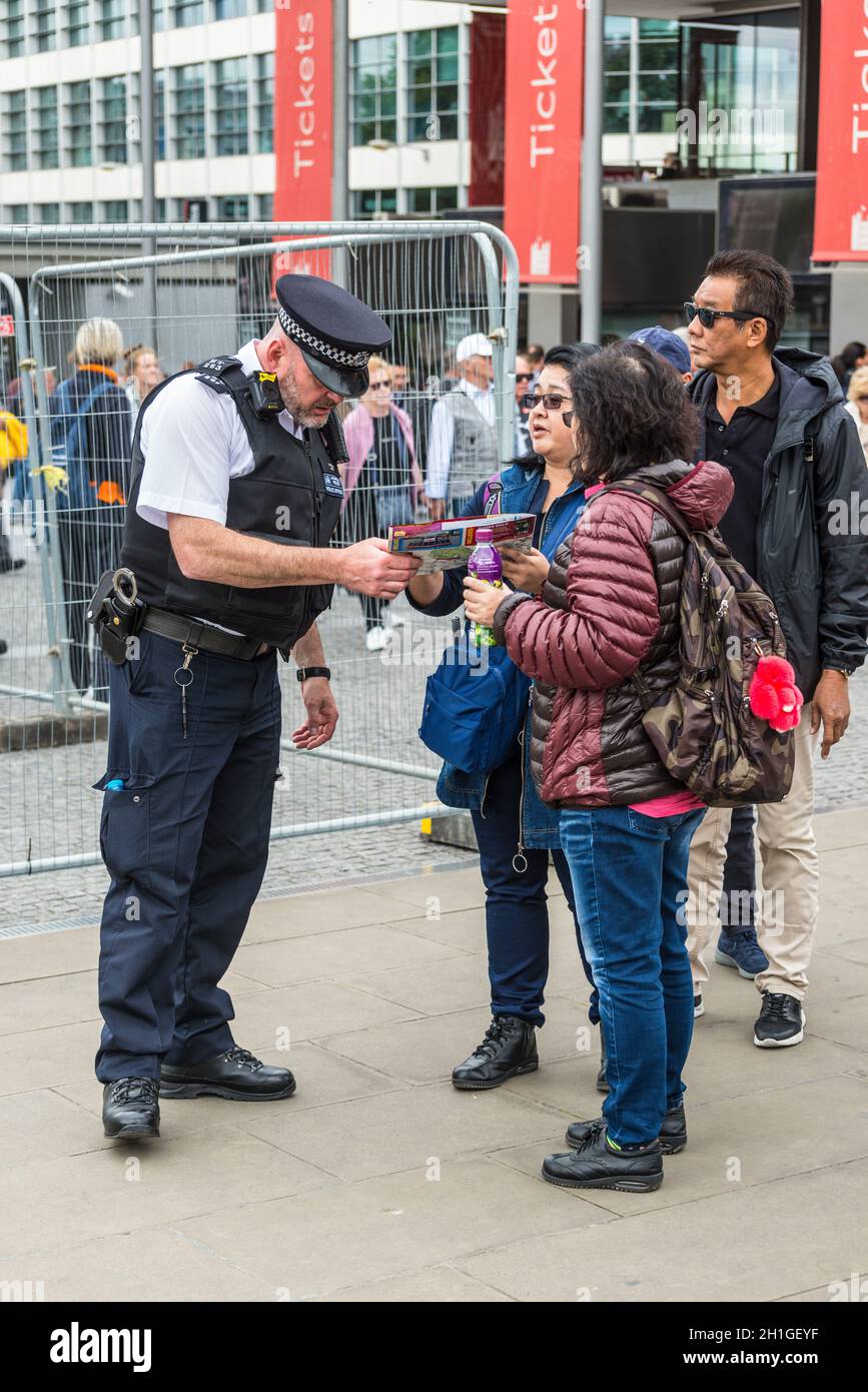 London, UK - May 23, 2017: Police officer help tourists with information near Tower of London, United Kingdom, Western Europe. Stock Photo